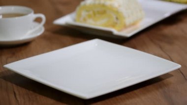 Bir tabak içinde bir parça koymak tatlı ananas rulo pasta