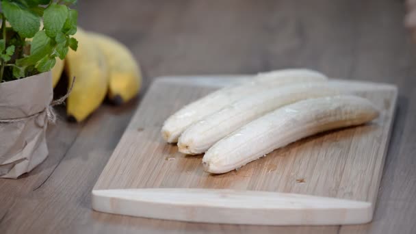 Άνθρωπος Κόβει Μπανάνα Μαχαίρι Στην Ξύλινη Σανίδα Στην Κουζίνα — Αρχείο Βίντεο