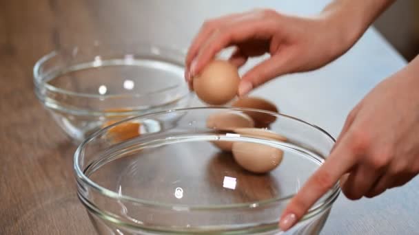 Női kéz eltöri a tojást, és elválasztja a sárgáját a fehértől.. — Stock videók
