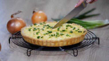 Soğan ve peynir ile Fransız tart. Soğan pasta bir mutfak bıçağıyla kesilmiş
