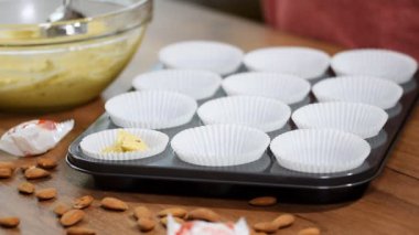 Kek hamuru ve bir kaşık ile cupcake sahipleri doldurma