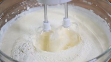 Şef cheesecakes yapmak için el ile bir kase sarı krem kamçı
