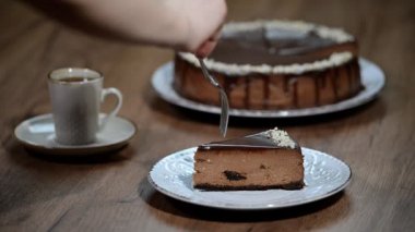 Çikolatalı cheesecake kahverengi bir arka plan üzerinde. Bir parça çikolata cheesecake yemek