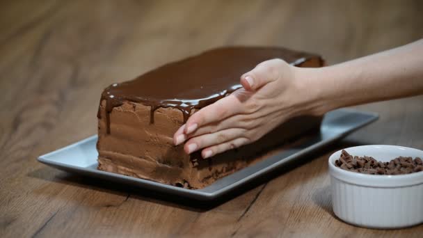 Pastelero decora un pastel de chocolate — Vídeo de stock