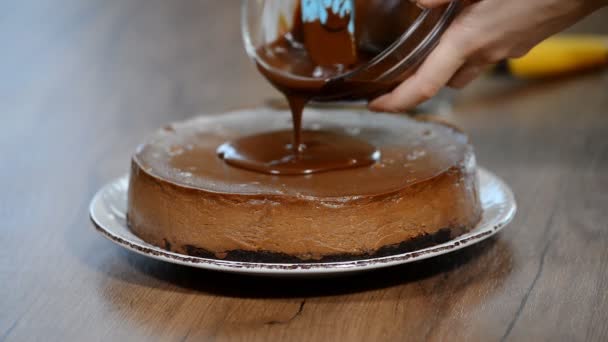 Pouring chocolate ganache on a chocolate cheesecake — Stock Video