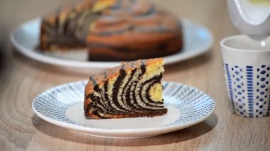 Çikolata sır ile '' Zebra'' pasta parçası. Bir bardağa süt dökme