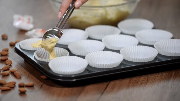 Concept de cuisine et de maison - gros plan des moules à muffins remplis à la main avec de la pâte — Video