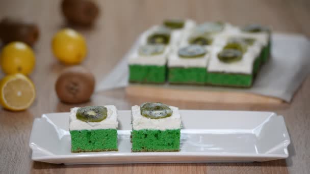 Выложить Белую Тарелку Зеленый Мягкий Торт Взбитыми Сливками Посыпать Киви — стоковое видео