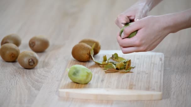 Een Kiwi Peeling Met Een Mes — Stockvideo