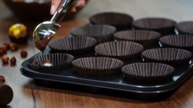 Dökülen kek hamuru tava içine. Bir kadın çikolata muffins yapma.