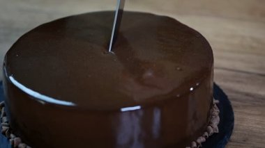 Cam çikolatalı mousse kek, yakın çekim. Çikolatalı pasta bir parça bir bıçak ile kesmek.