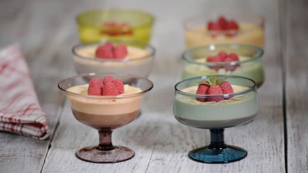 Raspberry with chocolate mousse in glass cups on a wooden background. Cream, sweetness. — Stock Video