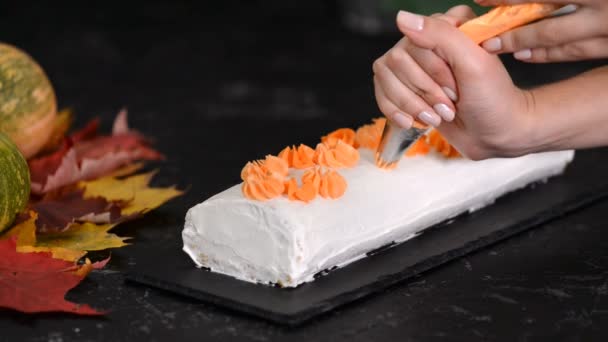 Woman decorates pumpkin roll with cream cheese. — Stock Video