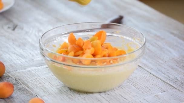 Chef add apricots to cake batter. The hand mix apricots with batter. Making apricots cake. — Stock Video