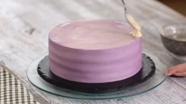 Manos pastelero prepara un pastel, vierta glaseado de chocolate blanco en el pastel . — Vídeos de Stock