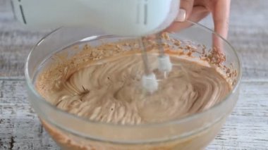 Profesyonel fırıncı pasta ya da hamur işleri için çikolatalı krema çırptı..