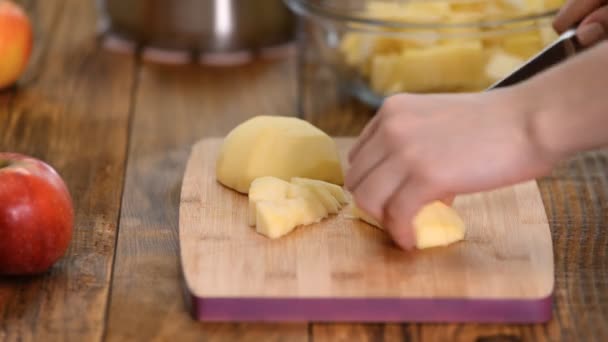 Koch schneidet Apfel auf Holzplanke in Küche. — Stockvideo