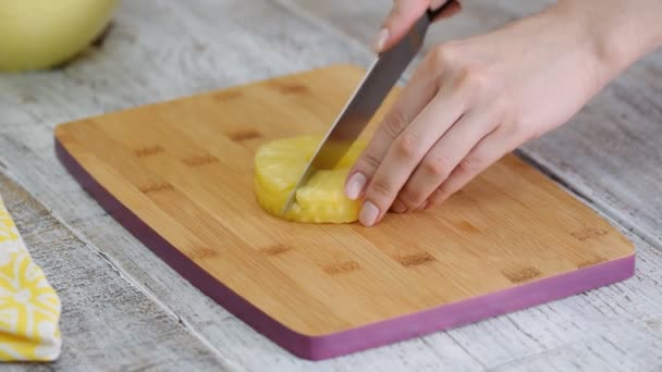 Cortar o abacaxi com uma faca numa tábua de corte . — Vídeo de Stock