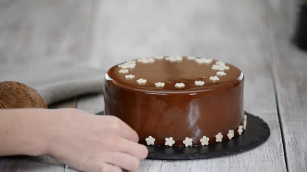 Femme décore gâteau de mousse au chocolat. Gâteau mousse chocolat avec glaçure miroir . — Video