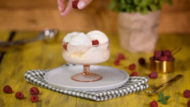Sobremesa de sorvete de baunilha com framboesas em tigela de vidro . — Vídeo de Stock
