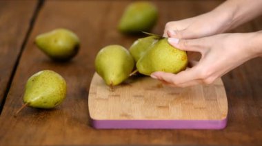 Masanın üzerinde armut soyan kadın..