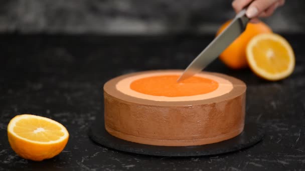 Woman cutting Orange Chocolate Mousse Cake with kitchen knife. — Stock Video