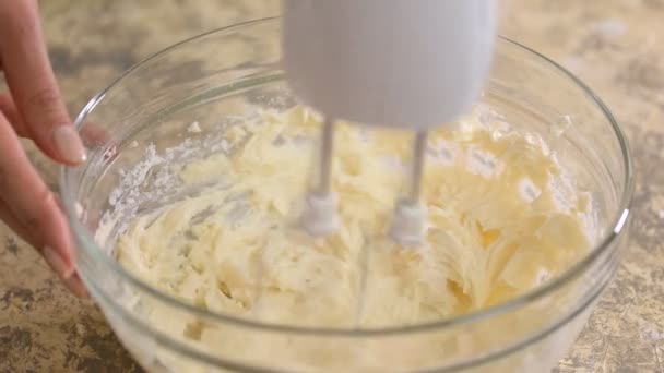 Die Sahne für den Kuchen mit dem Mixer verrühren. Nahaufnahme. — Stockvideo