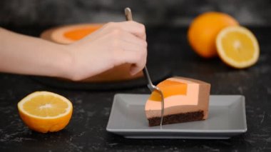 Portakallı çikolatalı kremalı pasta yiyen bir kadın..