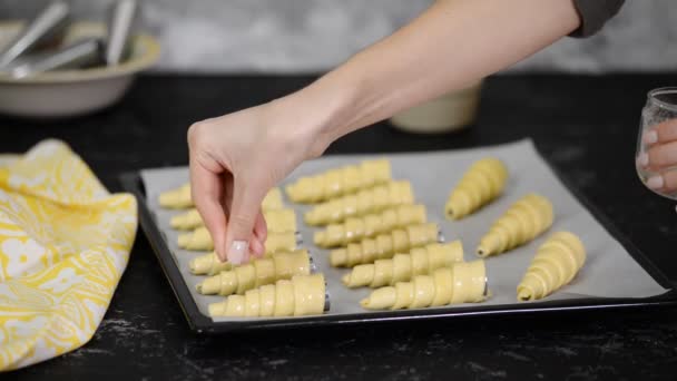 Woman in the kitchen making puff pastry horns. Sprinkle raw pastry horns with sugar. Series. — Stock Video