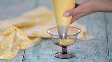 Şef, kremayı cam bir kaseye sıkıştırıyor..