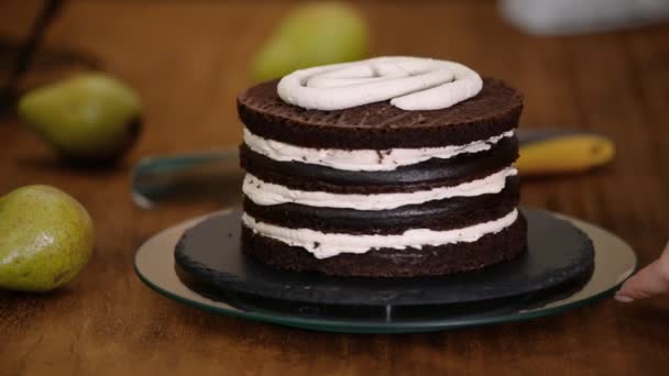 做巧克力蛋糕用梨子填饱肚子的糖果女人。 面包师妇女把奶油压在蛋糕上. — 图库视频影像