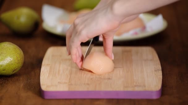 La donna taglia una pera bollita su un tagliere . — Video Stock