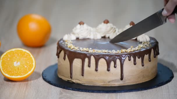 Close up de mão feminina cortando bolo de chocolate. Corte um pedaço de bolo de chocolate com uma faca . — Vídeo de Stock