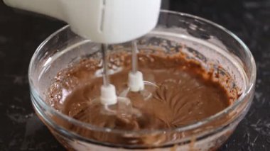 Kakao ile mikser çikolata hamuru kırbaçlama. Çikolata hamuru cam bir kapta bir mikser ile karıştırılır.