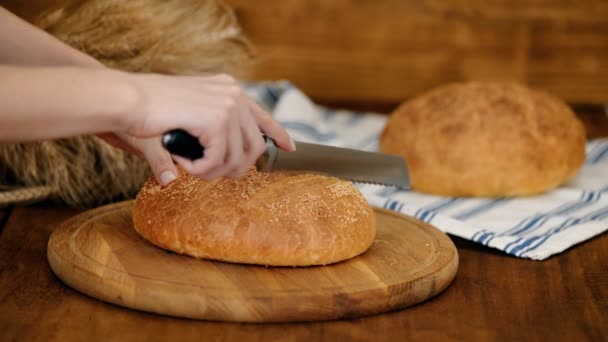 Vrouw snijden brood op houten plank. Bakkerij. Broodproductie. — Stockvideo