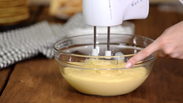 Frau schlägt Pudding mit Mixer in der Küche. — Stockvideo