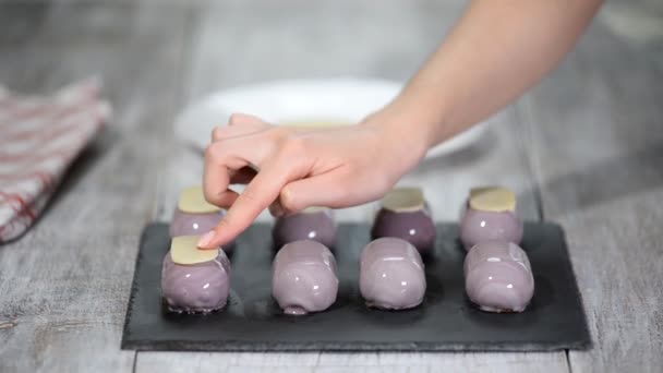 Przygotowanie nowoczesnych, francuskich deserów-mus z fioletowymi glazury lustro. Udekoruj francuskie ciasta z musem. — Wideo stockowe