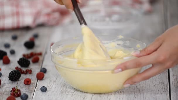 Cerrar revuelva la masa de pastel blanco en un tazón de vidrio . — Vídeos de Stock