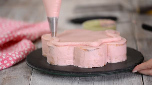 De banketbakker maakt een roze taart in de vorm van een bloem. Reeks. — Stockvideo