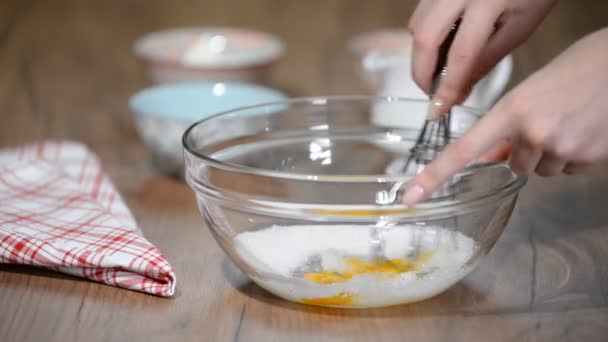 Соединяя яйца и сахар в стеклянную миску . — стоковое видео