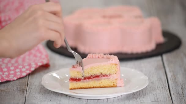 Eszik egy darab málnás tortát rózsaszín krémmel. — Stock videók