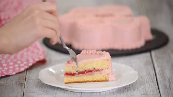 Ein Stück Himbeerkuchen mit rosa Sahne essen. — Stockvideo