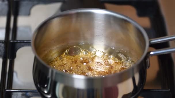Βραστό σιρόπι καραμέλας σε σόμπα σε κατσαρόλα κατσαρόλα. — Αρχείο Βίντεο