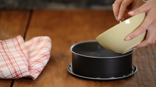 Mujer haciendo sabroso pastel de queso en la cocina. Hacer la base de la torta de galletas y mantequilla . — Vídeos de Stock