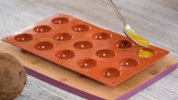 Aprire il ripieno in uno stampo di silicone. Il processo di preparazione del ripieno di mango per la mousse cake. Primo piano . — Video Stock