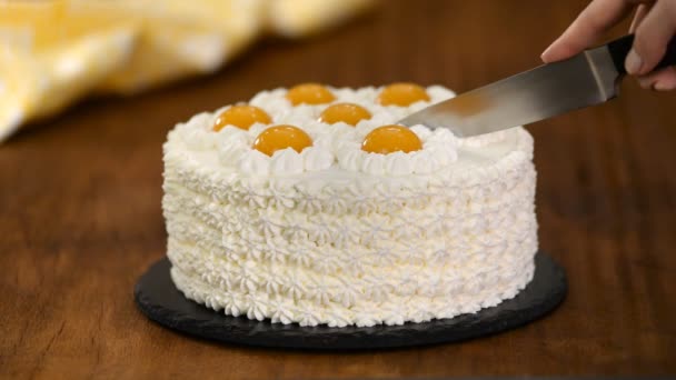 손으로 집에서 만든 크림 케이크를 복숭아로 자른다. — 비디오