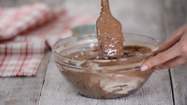 Chocoladetaart beslag maken. Gesmolten boter in het beslag gieten. — Stockvideo