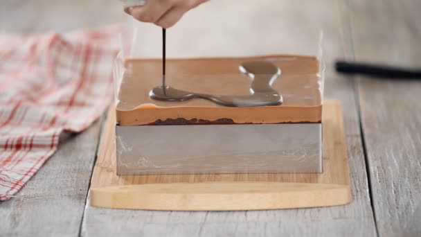 Acristalamiento pastel de chocolate con chocolate derretido. Mujer vertiendo chocolate sobre pastel. Pastel de cacao hecho en casa . — Vídeo de stock