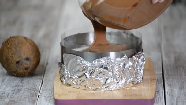 A fazer sobremesa de chocolate. Mãos femininas derrama mousse de chocolate no anel de confeitaria. Cozinhar bolo de chocolate . — Vídeo de Stock