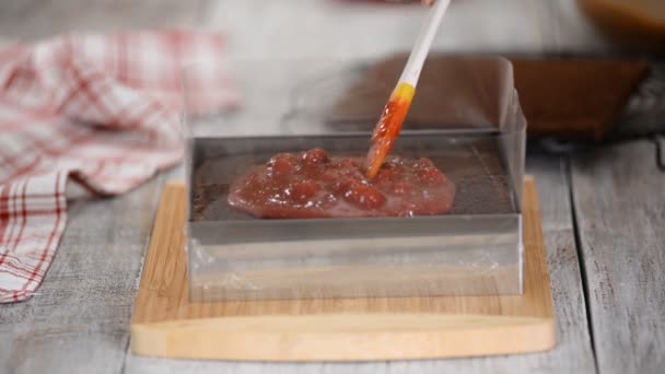 El concepto de cocinar. Un chef de pastelería profesional prepara un delicioso pastel de chocolate con relleno de cereza, primer plano . — Vídeos de Stock